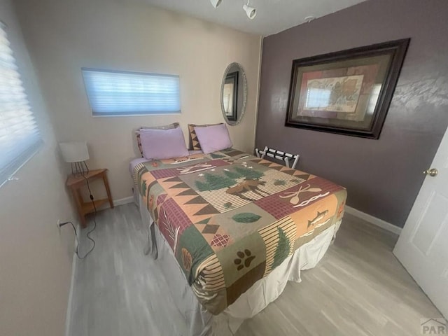 106 E 4th St, Antonito, CO 81120 - bedroom featuring wood finished floors, multiple windows, and baseboards
