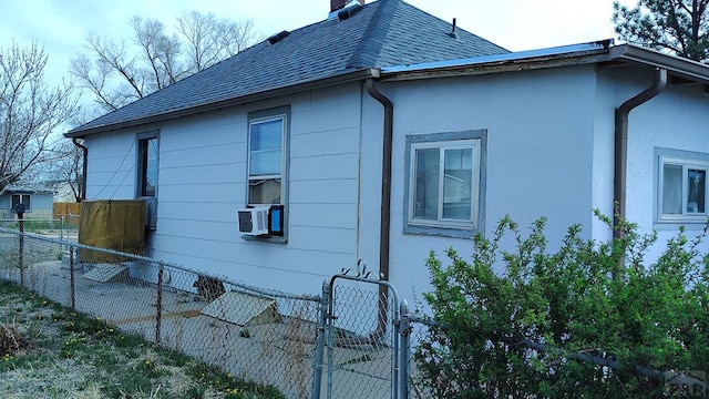 2318 W 17th St, Pueblo, CO 81003 - view of side of home featuring fence, roof with shingles, a chimney, a gate, and stucco siding
