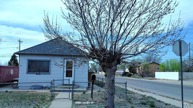 2318 W 17th St, Pueblo, CO 81003 - view of front of house featuring a shingled roof, a fenced front yard, and a gate