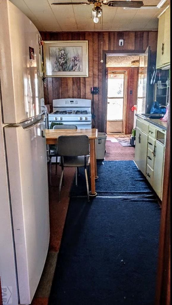 2318 W 17th St, Pueblo, CO 81003 - kitchen with white appliances and wood walls