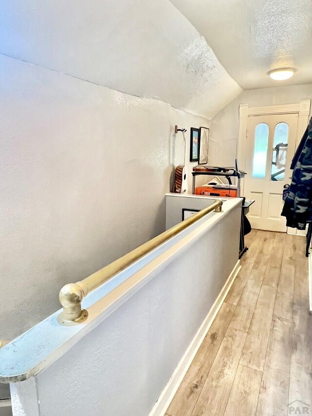 1127 W 12th St, Pueblo, CO 81003 - hall featuring a textured ceiling, lofted ceiling, and light wood-style flooring