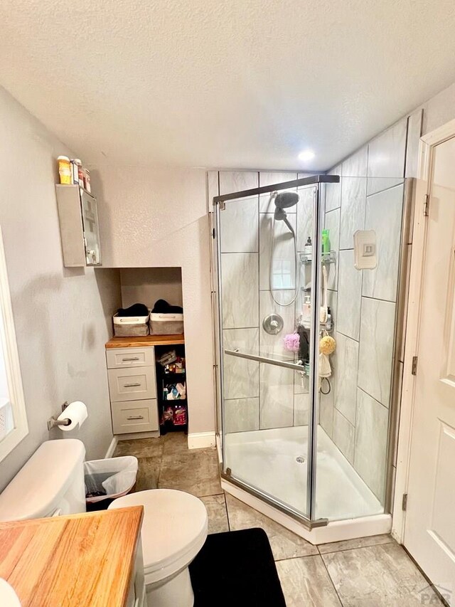 1127 W 12th St, Pueblo, CO 81003 - bathroom with toilet, a stall shower, and a textured ceiling