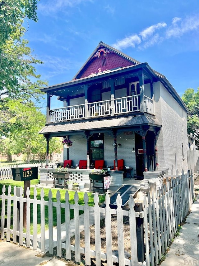 1127 W 12th St, Pueblo, CO 81003 - victorian house with a balcony, a porch, and a fenced front yard
