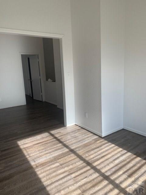 unfurnished room featuring dark wood-type flooring