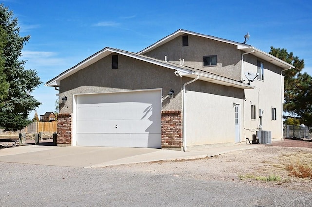 view of front of house with stucco siding, fence, and brick siding