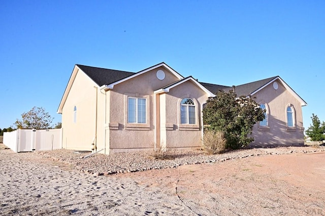 view of property exterior featuring fence and stucco siding