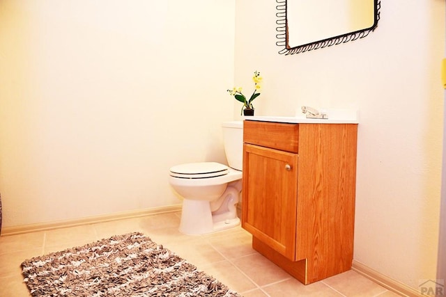 bathroom with baseboards, vanity, toilet, and tile patterned floors