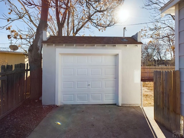 garage with fence and driveway