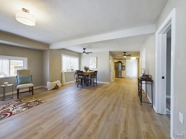 dining space with light wood-style floors, ceiling fan, and baseboards