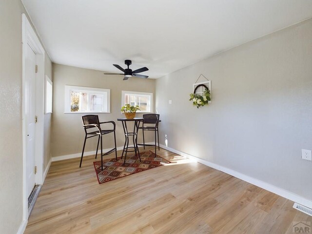 dining area featuring ceiling fan, visible vents, baseboards, and wood finished floors