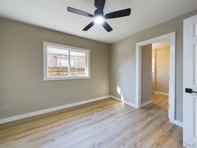 unfurnished room featuring ceiling fan, wood finished floors, and baseboards