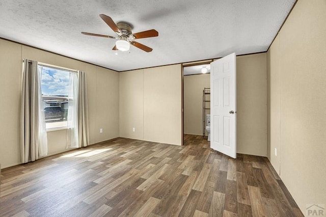 510 N 19th St Unit 13B, Canon City, CO 81212 - unfurnished bedroom with wood finished floors, a textured ceiling, and ceiling fan