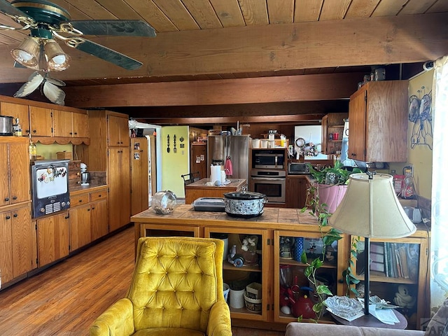 kitchen with brown cabinets, stainless steel appliances, and beam ceiling