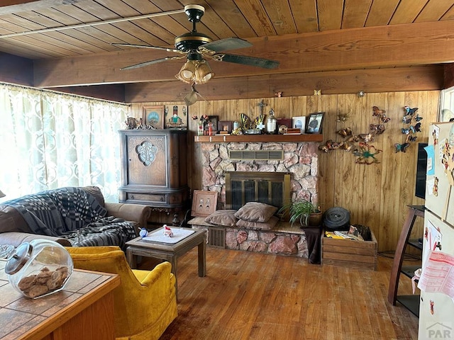 living room with wooden ceiling, wooden walls, a fireplace, wood finished floors, and beamed ceiling