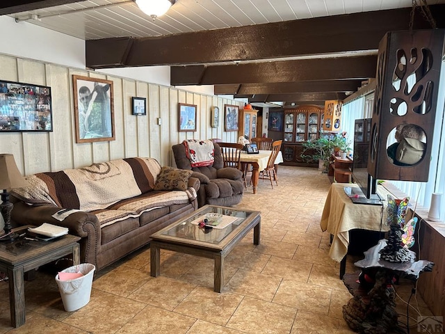 living area featuring wood walls and beam ceiling