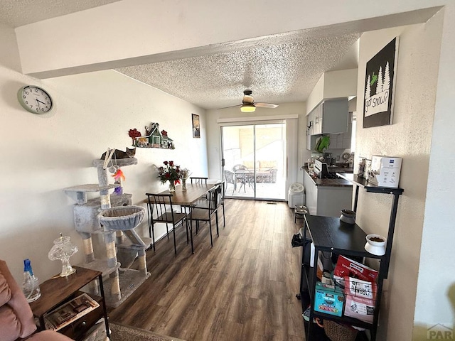 dining room with dark wood-type flooring, a textured ceiling, and a ceiling fan