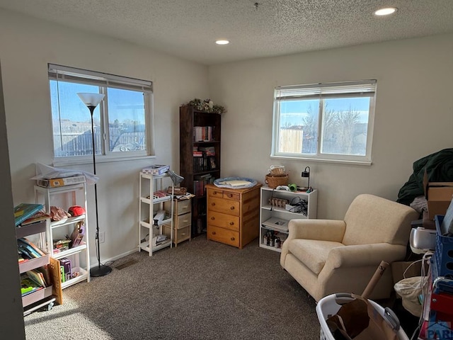 sitting room featuring dark colored carpet, a healthy amount of sunlight, a textured ceiling, and recessed lighting