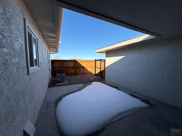 view of home's exterior with a fenced backyard, a patio, central AC unit, and stucco siding