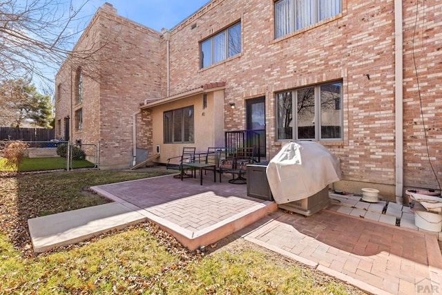 view of patio with fence and a grill