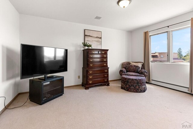 living area with carpet flooring, baseboard heating, and baseboards