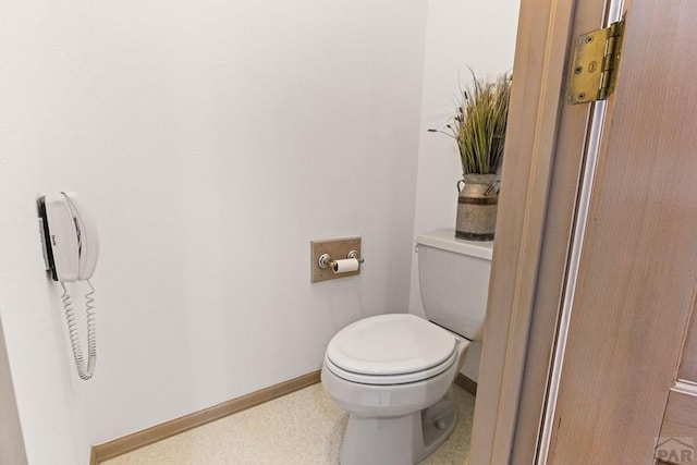 bathroom featuring toilet and baseboards