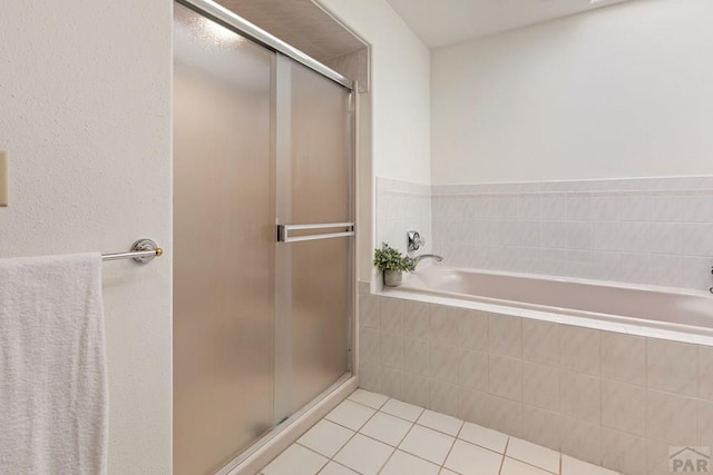 full bath featuring tile patterned floors, a bath, and a shower stall