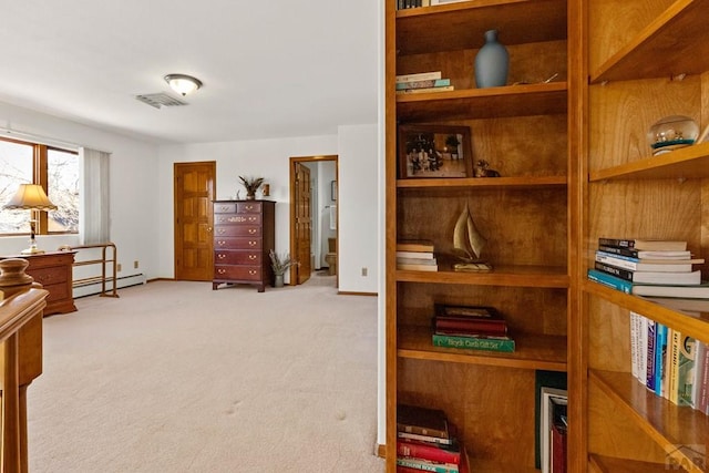 bedroom featuring a baseboard heating unit, baseboards, visible vents, and light carpet