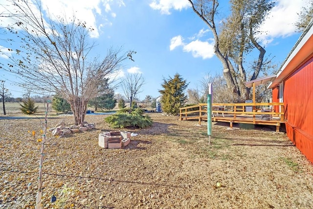 view of yard featuring an outdoor fire pit and a wooden deck