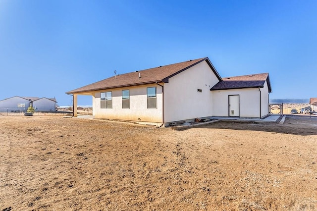 rear view of house with stucco siding