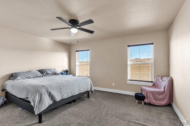 bedroom with carpet floors, a textured wall, a ceiling fan, a textured ceiling, and baseboards