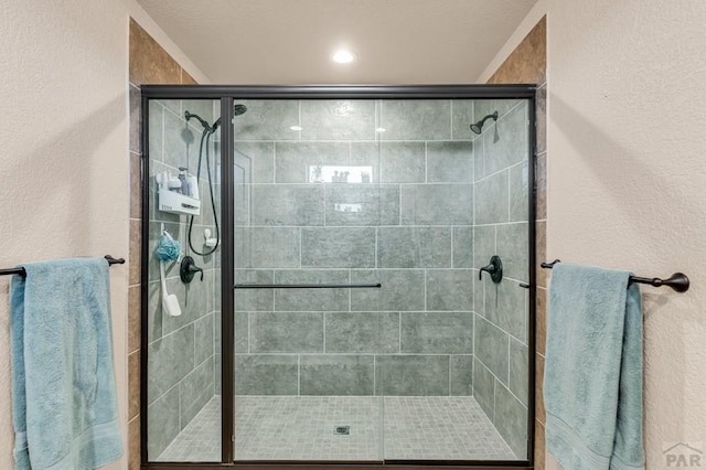 full bath featuring a stall shower and a textured wall