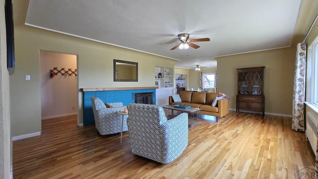 316 N Hooper Ave, Walsenburg, CO 81089 - living room with a ceiling fan, a fireplace, wood finished floors, and crown molding