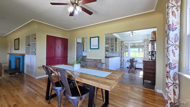 316 N Hooper Ave, Walsenburg, CO 81089 - dining area featuring wood finished floors, a ceiling fan, ornamental molding, a fireplace, and radiator