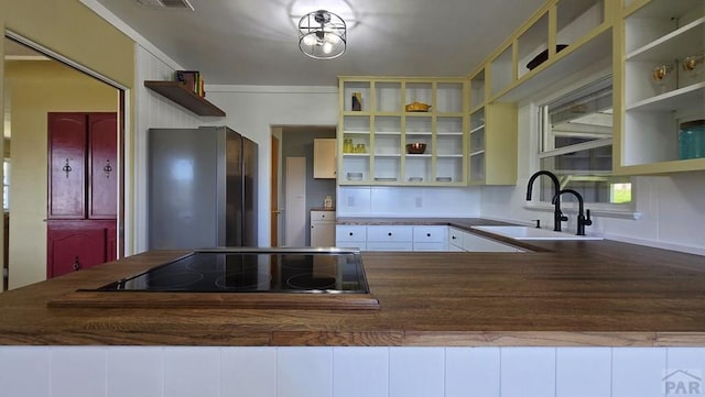 316 N Hooper Ave, Walsenburg, CO 81089 - kitchen featuring open shelves, freestanding refrigerator, black electric cooktop, a peninsula, and white cabinets
