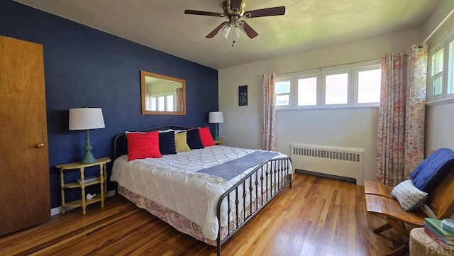 316 N Hooper Ave, Walsenburg, CO 81089 - bedroom with radiator heating unit, wood finished floors, multiple windows, and an accent wall