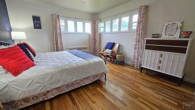 316 N Hooper Ave, Walsenburg, CO 81089 - bedroom with wood finished floors, multiple windows, and radiator heating unit