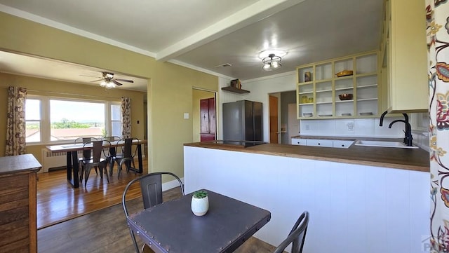 316 N Hooper Ave, Walsenburg, CO 81089 - kitchen with freestanding refrigerator, dark wood finished floors, a peninsula, a ceiling fan, and glass insert cabinets