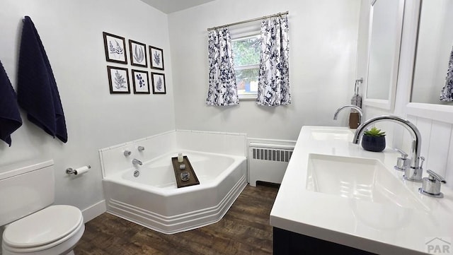 316 N Hooper Ave, Walsenburg, CO 81089 - bathroom with radiator, wood finished floors, double vanity, and a bath