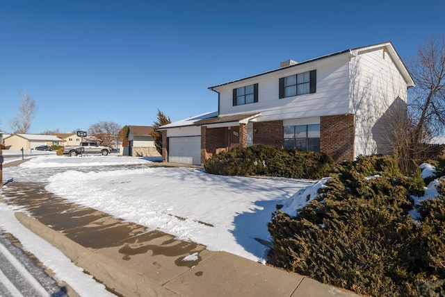 view of front of home with concrete driveway, brick siding, and an attached garage