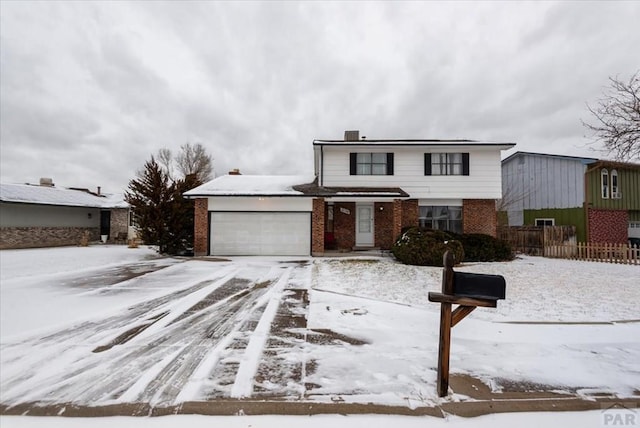 traditional-style home with brick siding, an attached garage, and fence