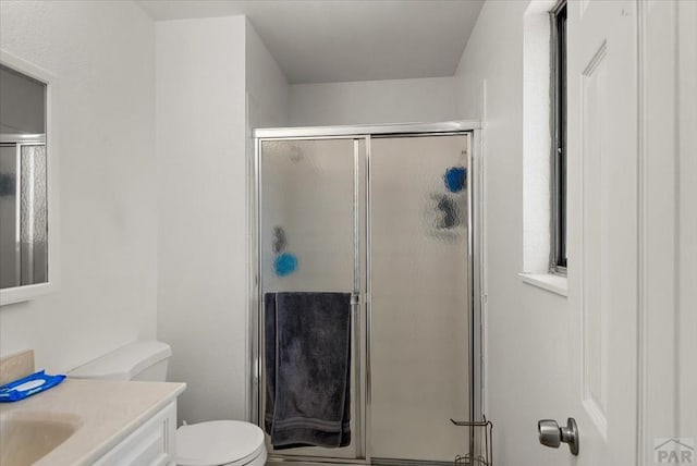 bathroom featuring a stall shower, vanity, and toilet