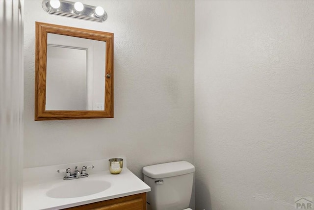 half bathroom with vanity and toilet