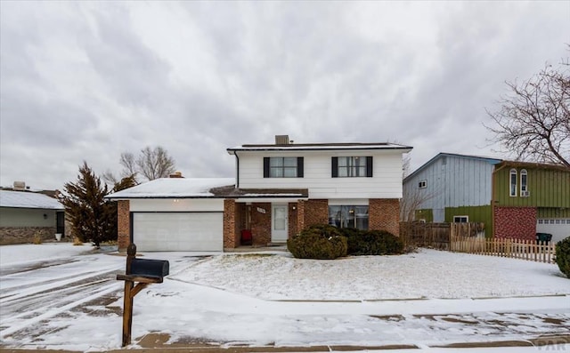 traditional-style house with an attached garage, fence, and brick siding