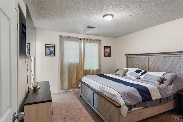 bedroom with a textured ceiling, carpet, and visible vents