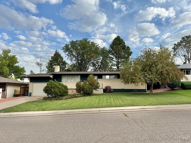 view of front of home featuring an attached garage, driveway, and a front yard