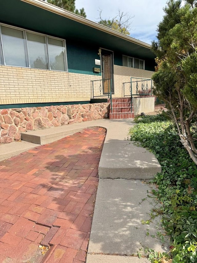 doorway to property featuring brick siding