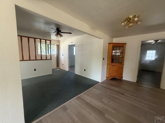 304 S Mullen, Lamar, CO 81052 - unfurnished living room with a ceiling fan, dark wood-type flooring, plenty of natural light, and a textured ceiling