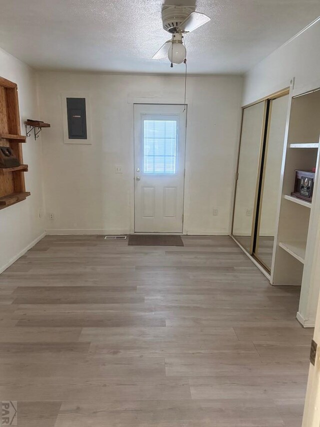 304 S Mullen, Lamar, CO 81052 - unfurnished dining area featuring electric panel, light wood finished floors, ceiling fan, and a textured ceiling