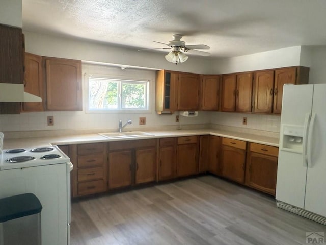 304 S Mullen, Lamar, CO 81052 - kitchen featuring white appliances, under cabinet range hood, brown cabinets, a ceiling fan, and a textured ceiling