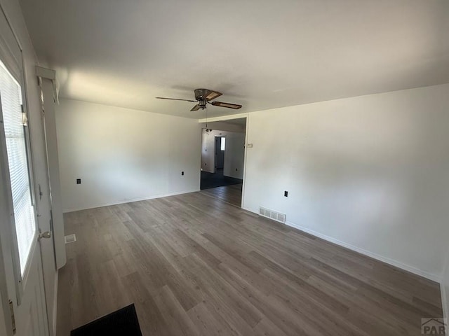 304 S Mullen, Lamar, CO 81052 - empty room featuring wood finished floors, ceiling fan, and plenty of natural light